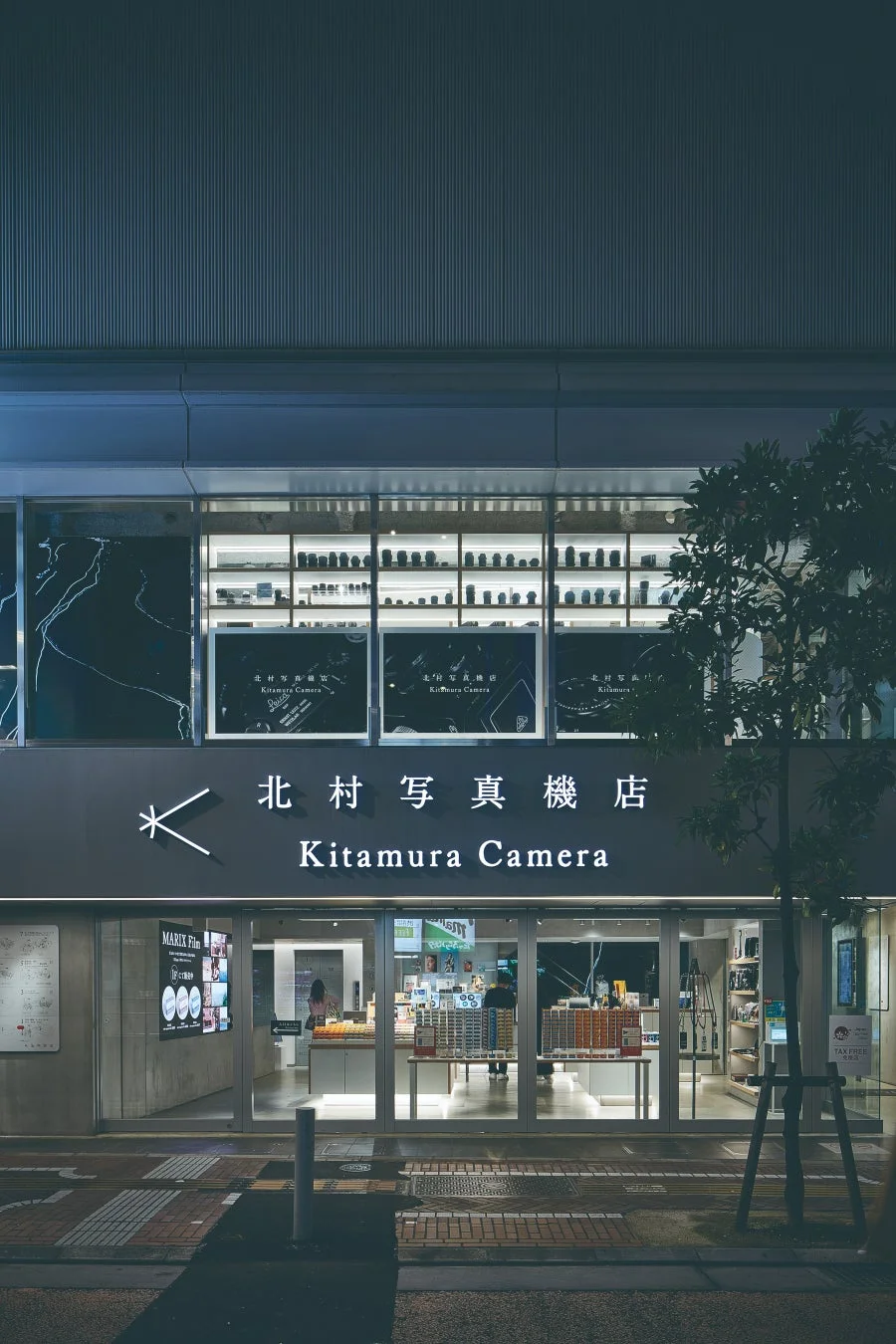 夜の街に佇む「北村写真機店」のモダンな外観