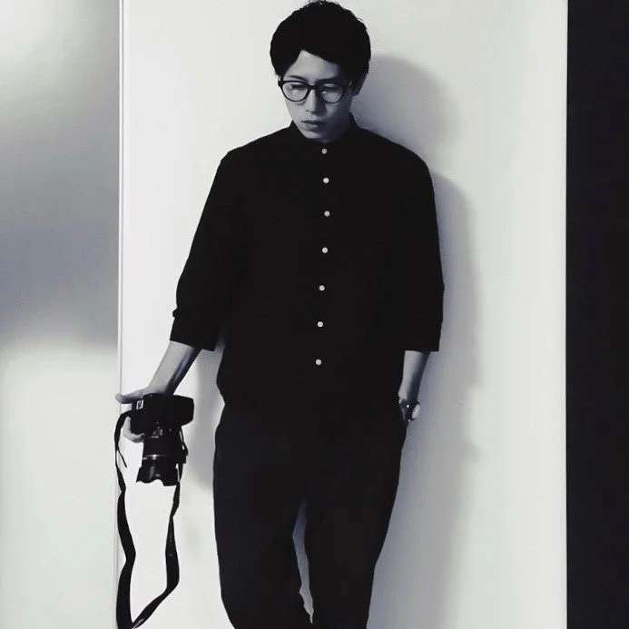 カメラを持つphoto_booooy氏のモノクロポートレート